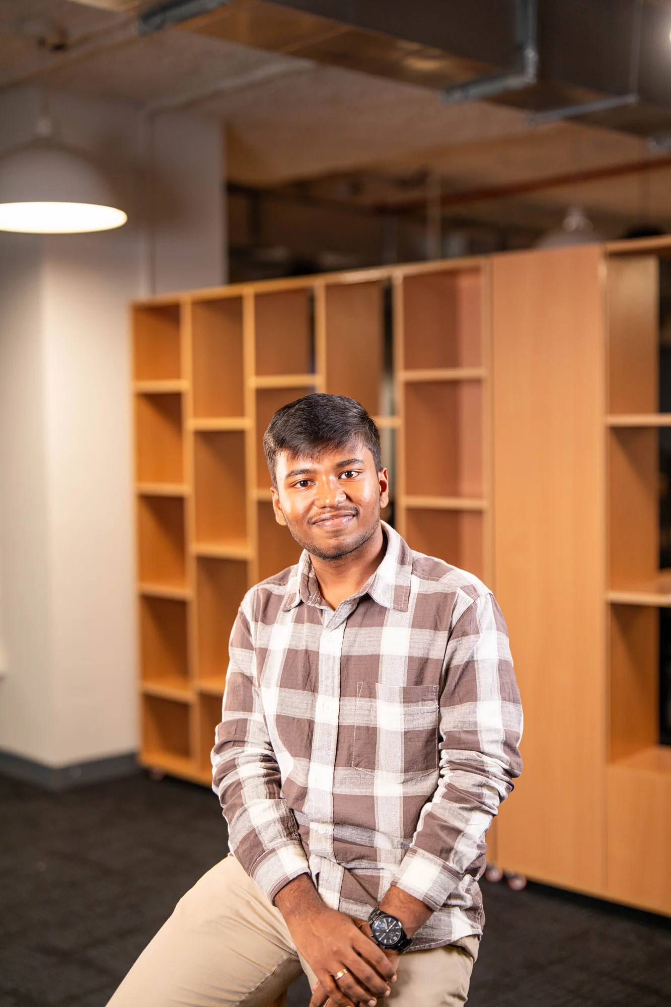 Harsha Biyyapu seated in a bright campus space